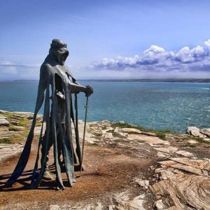 statue of king arthur on cliffside overlooking the sea, clouds in sky, tintagel, north cornwall